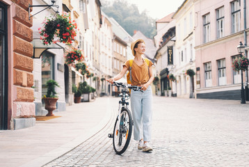 Girl with backpack and bicycle explores Ljubljana. Travel Slovenia