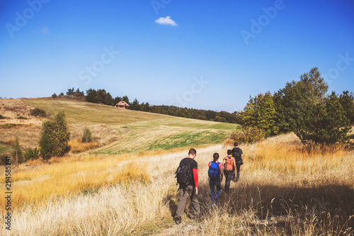 Fotomural Rear view of unrecognizable people with backpack hiking in the nature