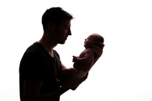 Silhouette Of A Father Holding His Newborn Baby