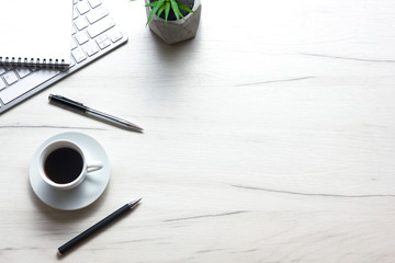 White desk office with laptop, smartphone and other work supplies with cup of coffee. Top view with copy space for input the text. Designer workspace on desk table essential elements on flat lay