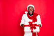 © deagreez - Wow its for me. Portrait of excited african man in santa claus cap hold big package get present for newyear celebration party from his friend wear style jumper isolated over red color background