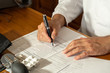 Cropped image of male doctor's hands writing medical prescription and updating medical report