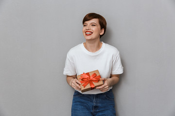 Poster - Image of happy young woman smiling and holding present box