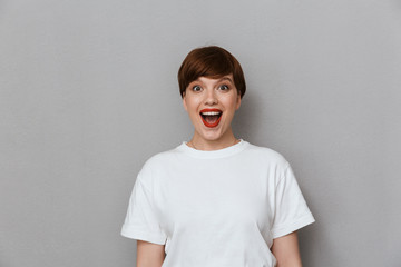 Sticker - Image of surprised brunette woman wearing casual t-shirt expressing wonder and laughing at camera