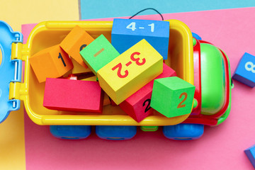 Wall Mural - Truck full of colorful child kid’s education toys constructor cart pattern background on the bright color background close up. Childhood education play infancy children baby concept