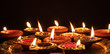 © Rawf8 - Diwali, Hindu festival of lights celebration. Diya oil lamps against dark background,