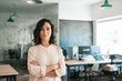 © mavoimages - Confident young businesswoman standing with her arms crossed at work