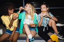 Image Of Party Girls Eating Fastfood And Drinking Soda At Night