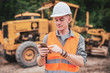 © Pituk - Portrait of caucasian engineers use smartphones in the workplace. Road construction site