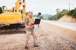 © Pituk - Caucasian handsome engineer using a laptop on road construction site. Engineer work concept