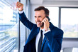 © baranq - Happy successful businessman in office talking on the phone