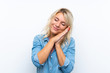 © luismolinero - Young blonde woman over isolated white background making sleep gesture in dorable expression