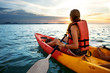 © Rock and Wasp - Couple kayaking together. Beautiful young couple kayaking on lake together and smiling at sunset