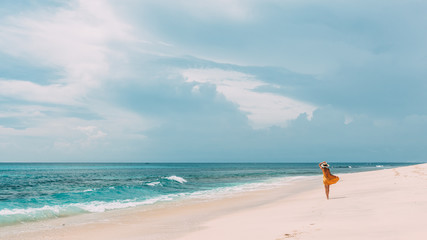 Wall Mural - Woman walking in blue lagoon with paradise view