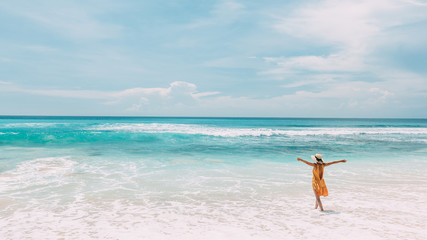 Wall Mural - Woman walking in blue lagoon with paradise view