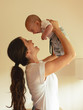 © BalanceFormCreative - Mother holds her baby and laughing together.Home family concept.