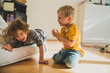 © Mareen Fischinger - Zwei Kinder raufen im Wohnzimmer