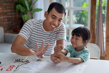 toddler learning math and counting with her father at home together