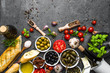 Italian food or mediterranean cooking ingredients. Herbs, olive, olil, tomato, bread, cheese and wine bottle.