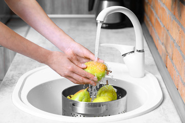 Sticker - Woman washing fresh ripe pears in kitchen sink, closeup