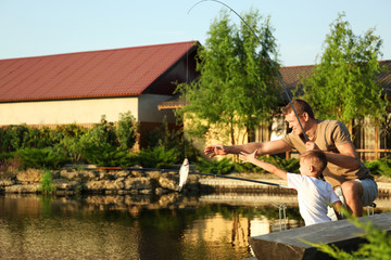 Wall Mural - Dad and son fishing together on sunny day