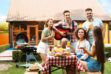 Canvas Print - Happy friends with drinks having fun at barbecue party outdoors