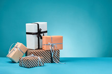 Different Sizes, Colorful, Striped And Plain Paper Gift Boxes Tied With Ribbons And Bows On A Blue Surface And Background. Close-up, Copy Space.