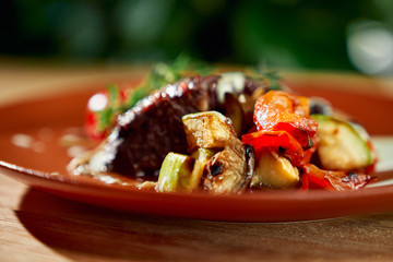 Wall Mural - Closeup of grilled vegetables served with juicy meat