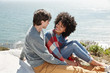 © Trinette Reed/Stocksy - Mixed race couple sitting on a blanket overlooking the ocean