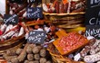Different kinds of French salami provencale presented in wicker baskets with handwritten chalk boards on farmer market - St. Tropez, France