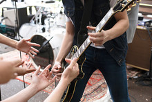 Anonymous Performer Playing Electric Guitar With Fans Hands