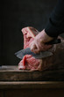 © Alberto Bogo/Stocksy - Hand cutting meat with knife