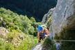 © k5hu - Woman on via ferrata at Vadu Crisului, Romania, on a rock wall called Peretele Zanelor, above Crisul Repede river, on a warm sunny day. Copy space on the left.
