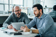 © FS Productions/Tetra Images - Men using digital tablet during meeting in office