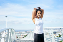 Young Fit Urban Woman Stretching Whilst Working Out On A City Walkway