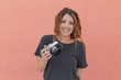 © rzcreative/Stocksy - Portrait of woman with camera against blank wall.