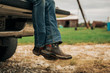 © Cavan Images - American flag cowboy boots on pickup truck tailgate
