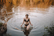 © Cavan Images - Young woman in bikini walking in lake