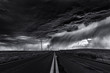© Cavan Images - Heavy storm and cloudy sky over road and farm fields, black and white