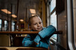 © Cavan Images - Young boy sat on a train smiling