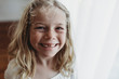 © Cavan Images - Portrait of young freckled smiling girl missing tooth