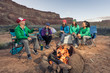 © Cavan Images - A group of women sit by a campfire in the desert