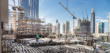 Laborers Working On Modern Constraction Site Works In Dubai. Fast Urban Development Consept.