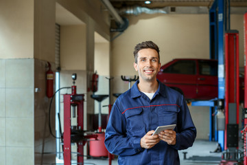 Wall Mural - Male mechanic with tablet computer in car service center