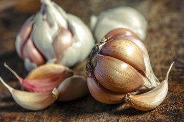 Organic garlic,Closeup garlic on wooden texture on for cooking on dark background, concept healthy lifestyle.Fresh peeled garlics and bulbs.