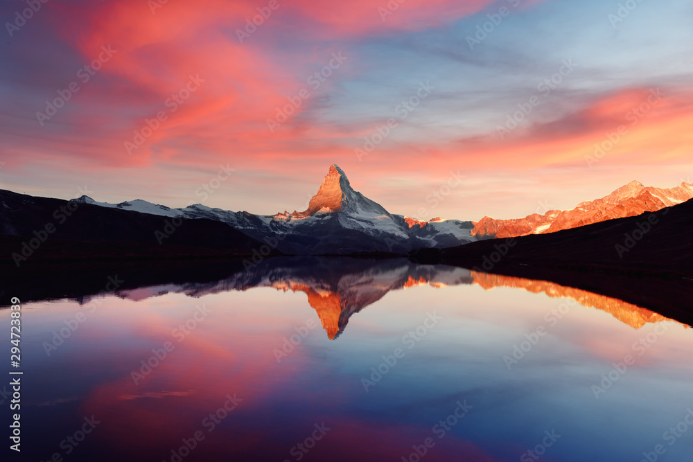 Splendid landscape with colorful sunrise on Stellisee lake. Snowy Matterhorn Cervino peak with reflection in clear water. Zermatt, Swiss Alps - obrazy, fototapety, plakaty 