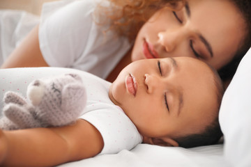 Sticker - Young African-American woman and her baby sleeping on bed