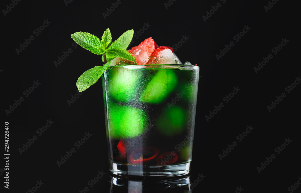 Glass of tasty cocktail on dark background