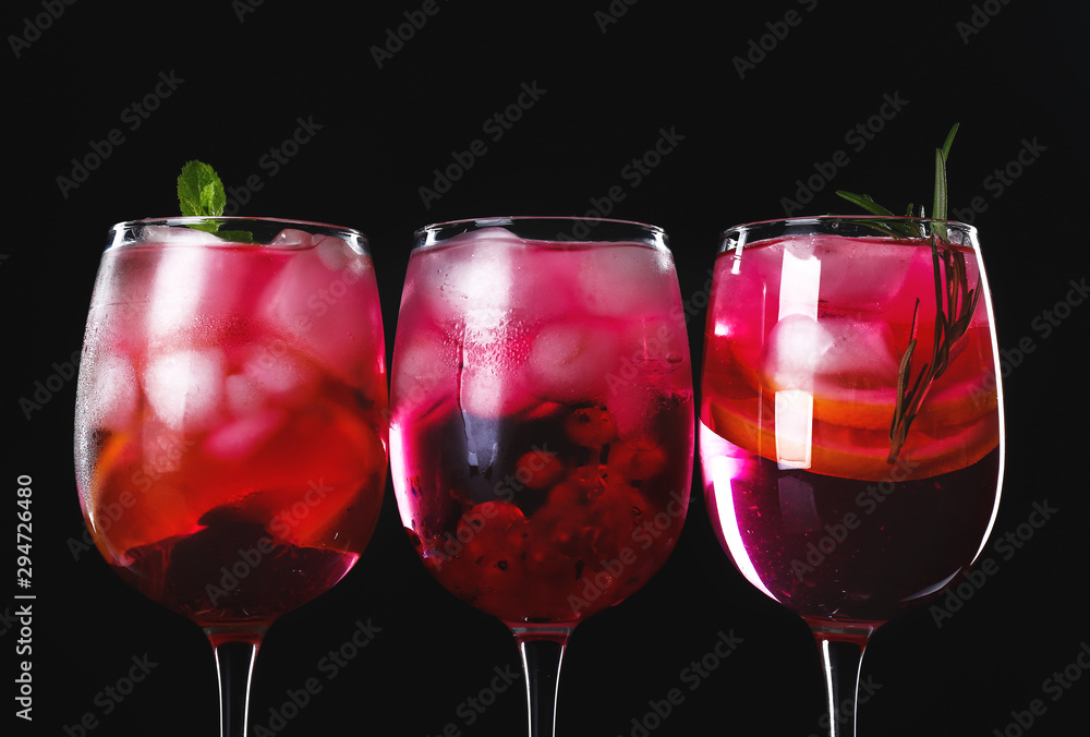 Different tasty cocktails on dark background