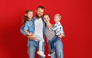 happy family mother father and children daughter and son  near an   red wall